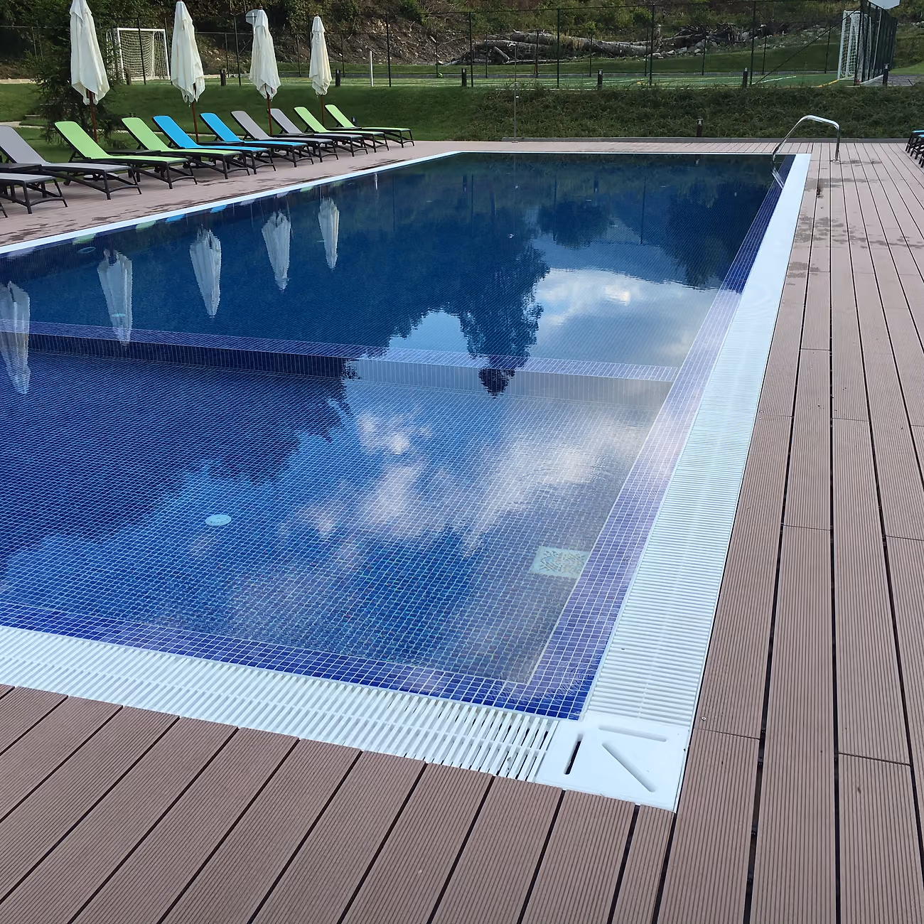 The pool corner in close-up, showing the overflow channel and the mosaic tiles under the water