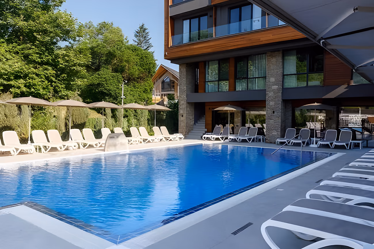 The rectangular pool in front of the hotel building, ringed by loungers and umbrellas